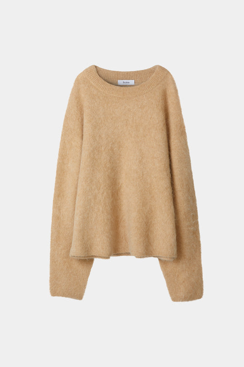 model wearing a beige sweater and gray pants on a white background, stylein, lorena
