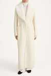 white maxi wool coat with a faux fur collar stylein tera thivona model image