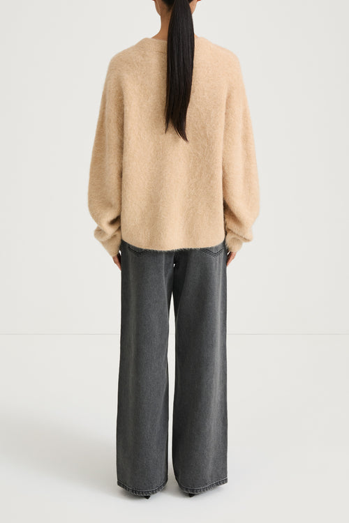 model wearing a beige sweater and gray pants on a white background, stylein, lorena, back