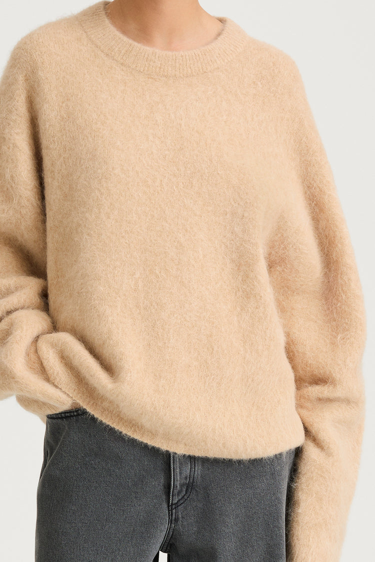 model wearing a beige sweater and gray pants on a white background, stylein, lorena, detail image
