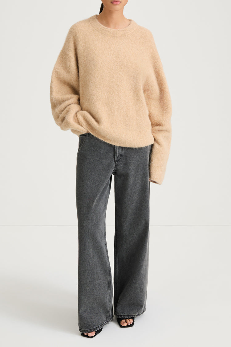 model wearing a beige sweater and gray pants on a white background, stylein, lorena