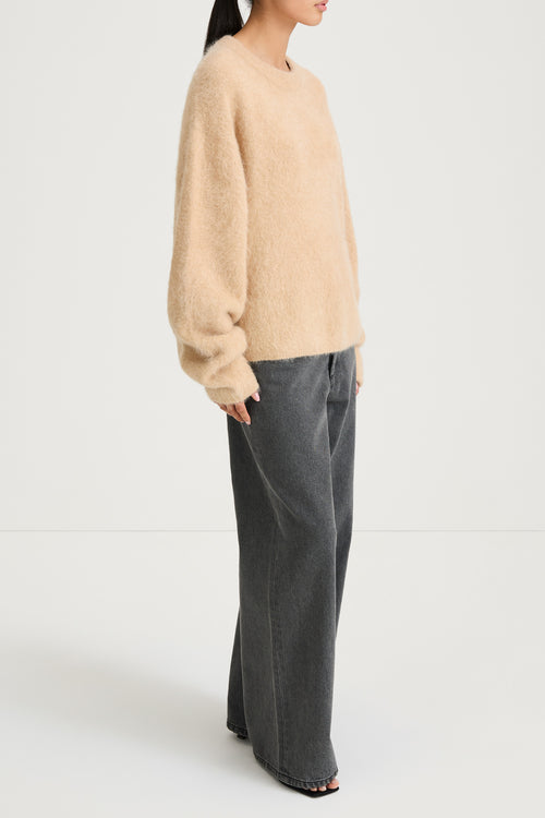 model wearing a beige sweater and gray pants on a white background, stylein, lorena, side